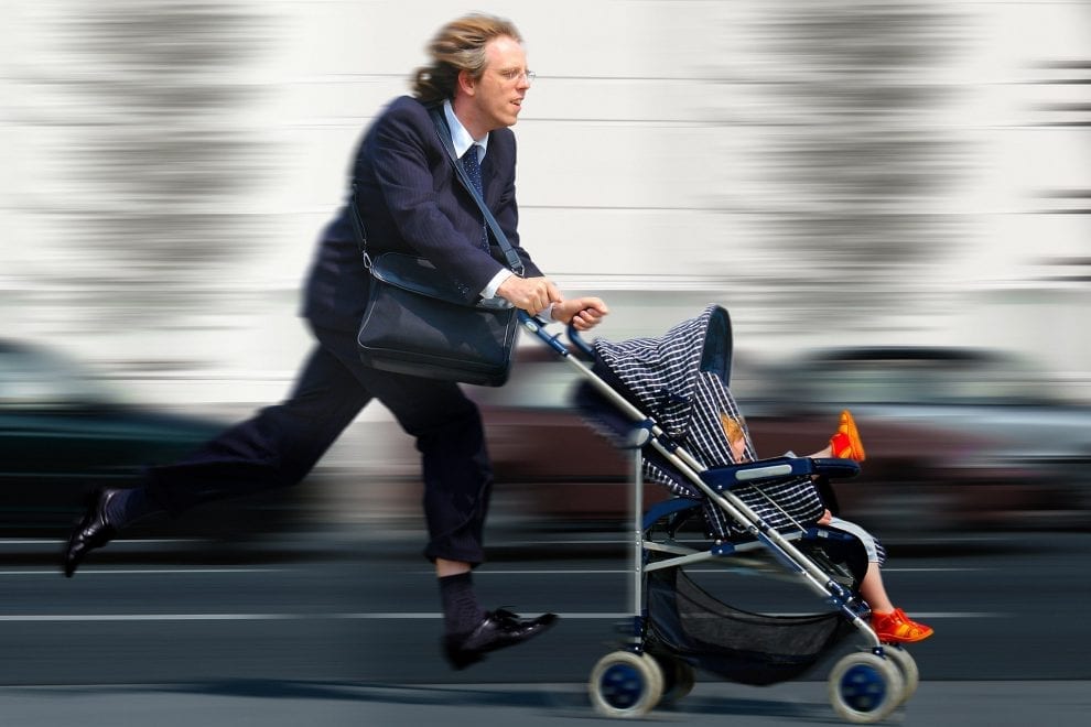 Foto eines Vaters mit Kinderwagen in Hektik