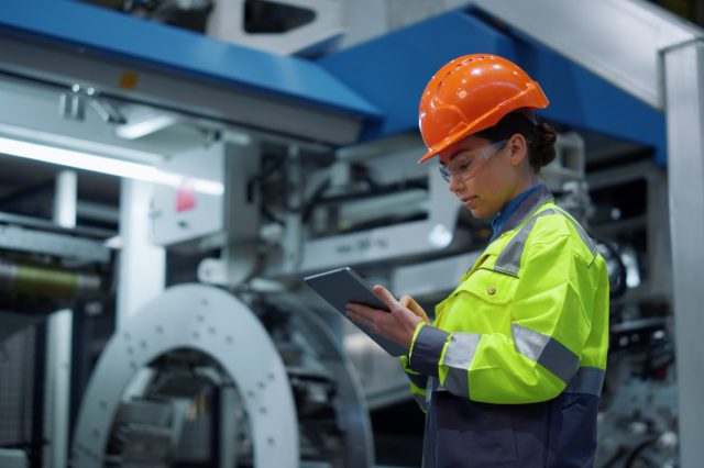 Arbeiterin mit Taschenrechner in einer Fabrik. Symbolfoto für Benya-Formel, herbstlohnrunde und KV-Verhandlungen