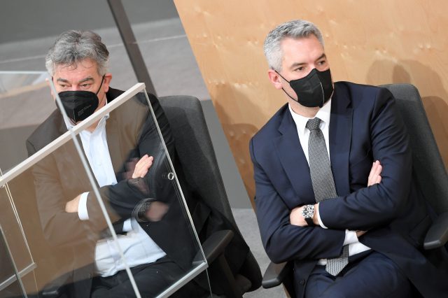 Vizekanzler Werner Kogler (Grüne) und Bundeskanzler Karl Nehammer (ÖVP) im Nationalrat. Symbolbild für die KV-Verhandlungen und den Umgang mit Krisen.