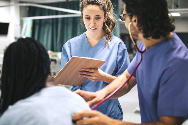 Personal aus der Pflege unterhält sich mit einem Patienten. Symbolbild für die KV-verhandlungen im Sozialbereich während der Herbstlohnrunde 2023.