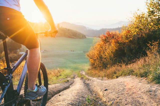 Eine Vier-Tage-Woche garantiert mehr Freizeit. Das Bild zeigt das Bein eines Mountainbikers.