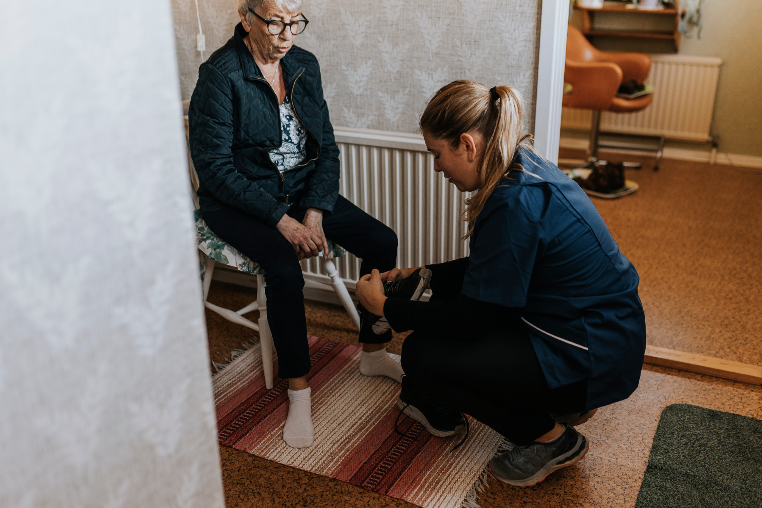 Eine Betreuerin in der Heimpflege zieht einer Pensionisten die Schuhe an. Die Pflegereform soll die Arbeitsbedingungen verbessern. 