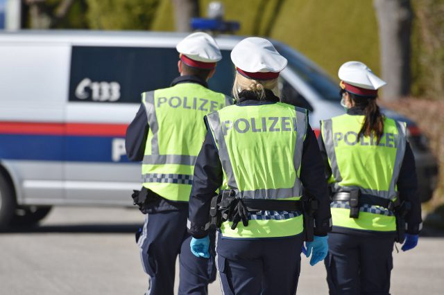 Die Jugend in Österreich vertraut der Polizei. Polizisten von hinten.