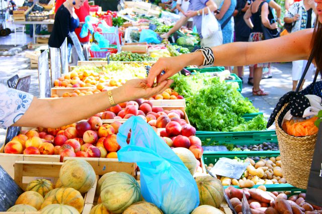 Eine Frau kauft auf dem markt Lebensmittel. Symbolbild für Inflation in Österreich.