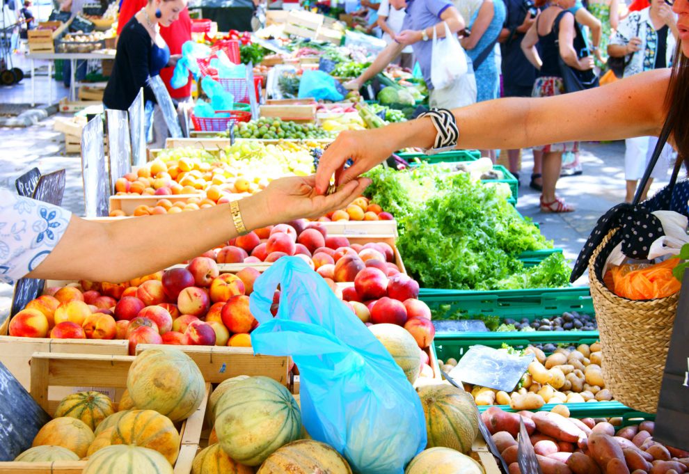 Eine Frau kauft auf dem markt Lebensmittel. Symbolbild für Inflation in Österreich.