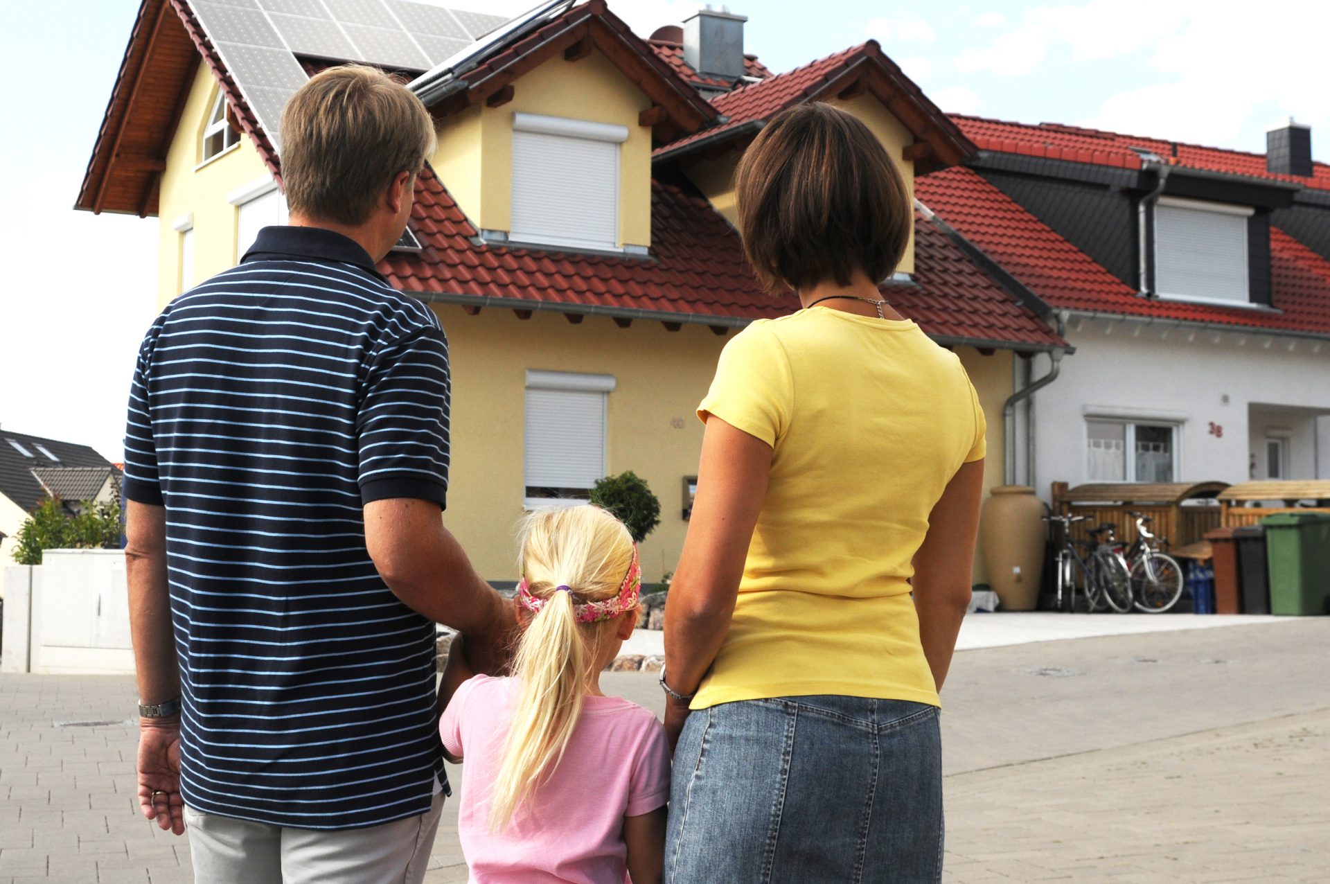 Familie vor einem Haus, Hausbau