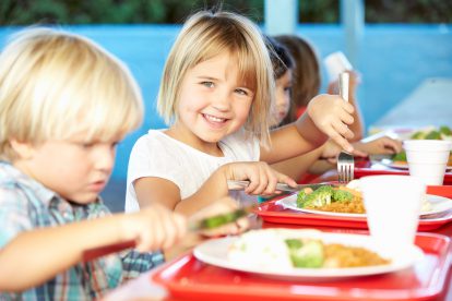Kinder essen in der Schule. Symbolbild für Ganztagsbetreuung.