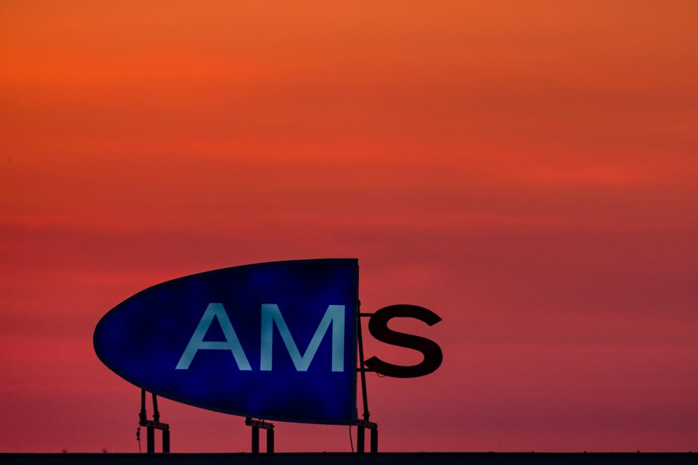 Logo des AMS im Sonnenuntergang. Aufgrund der Stillen Reserve wäre die Arbeitslosigkeit in Österreich viel höher.