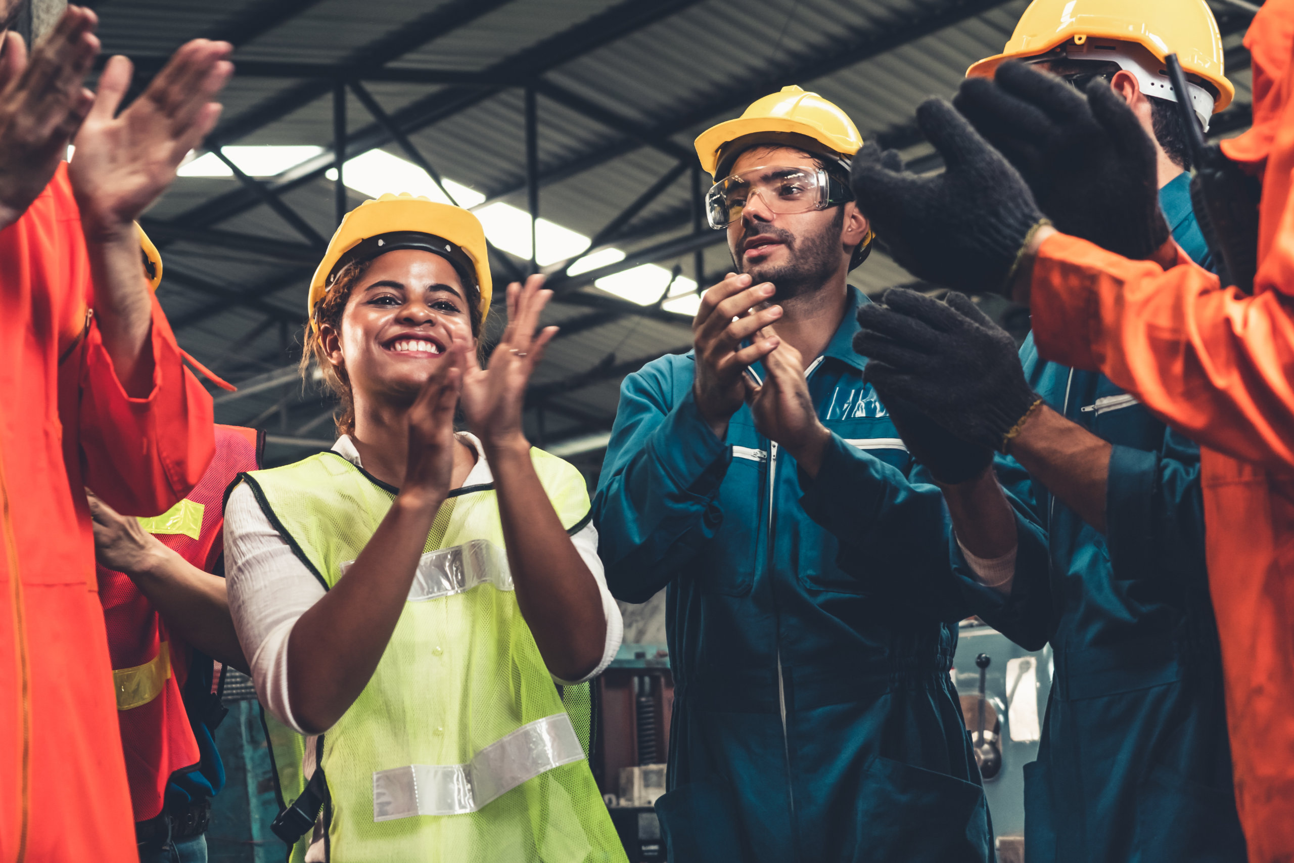 Arbeiter und Arbeiterin in einer Fabrik mit Helm. Symbolbild für die Ergebnisse der KV-Verhandlungen der Metaller 2022.