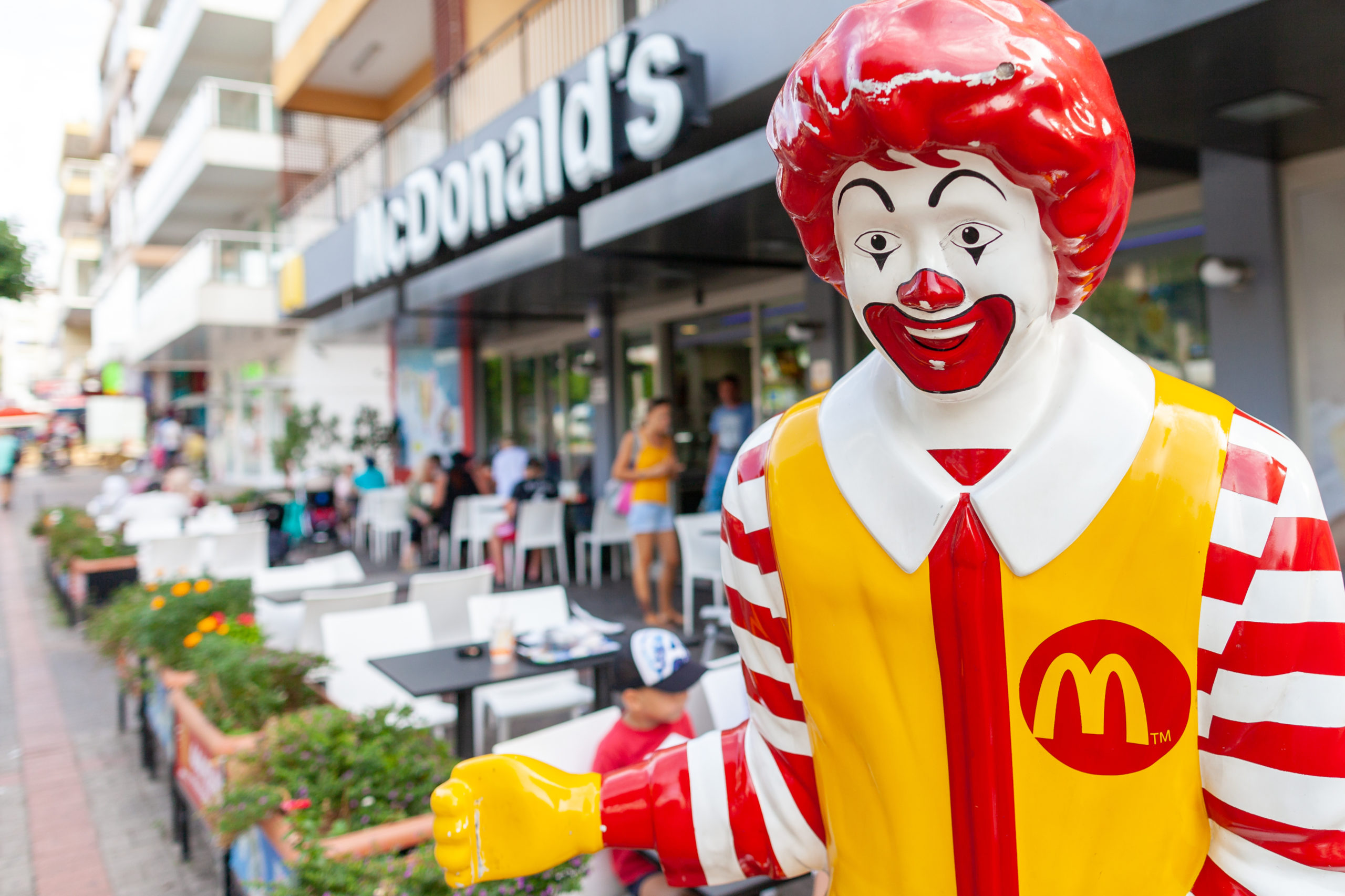 Ronald McDonald deutet auf den Eingang einer McDonalds Filliale. Symbolbild für die Überförderung von Unternehmen in Österreich.
