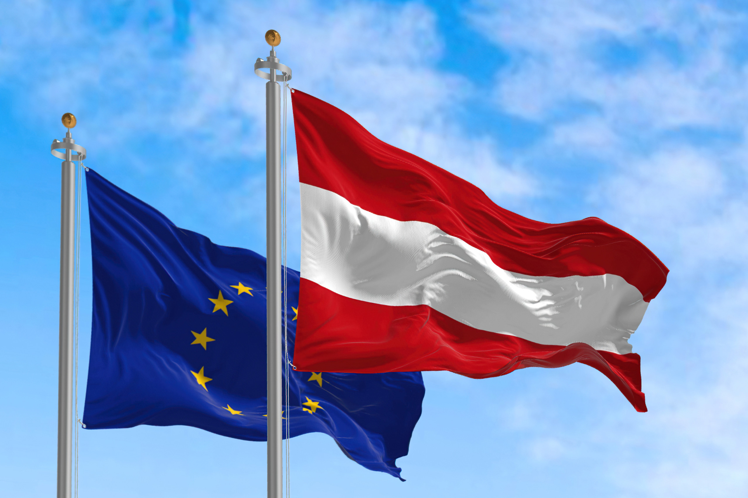Eine EU-Fahne weht neben einer Österreichflagge. Symbolbild für den Nachhaltigkeitsbericht. 
