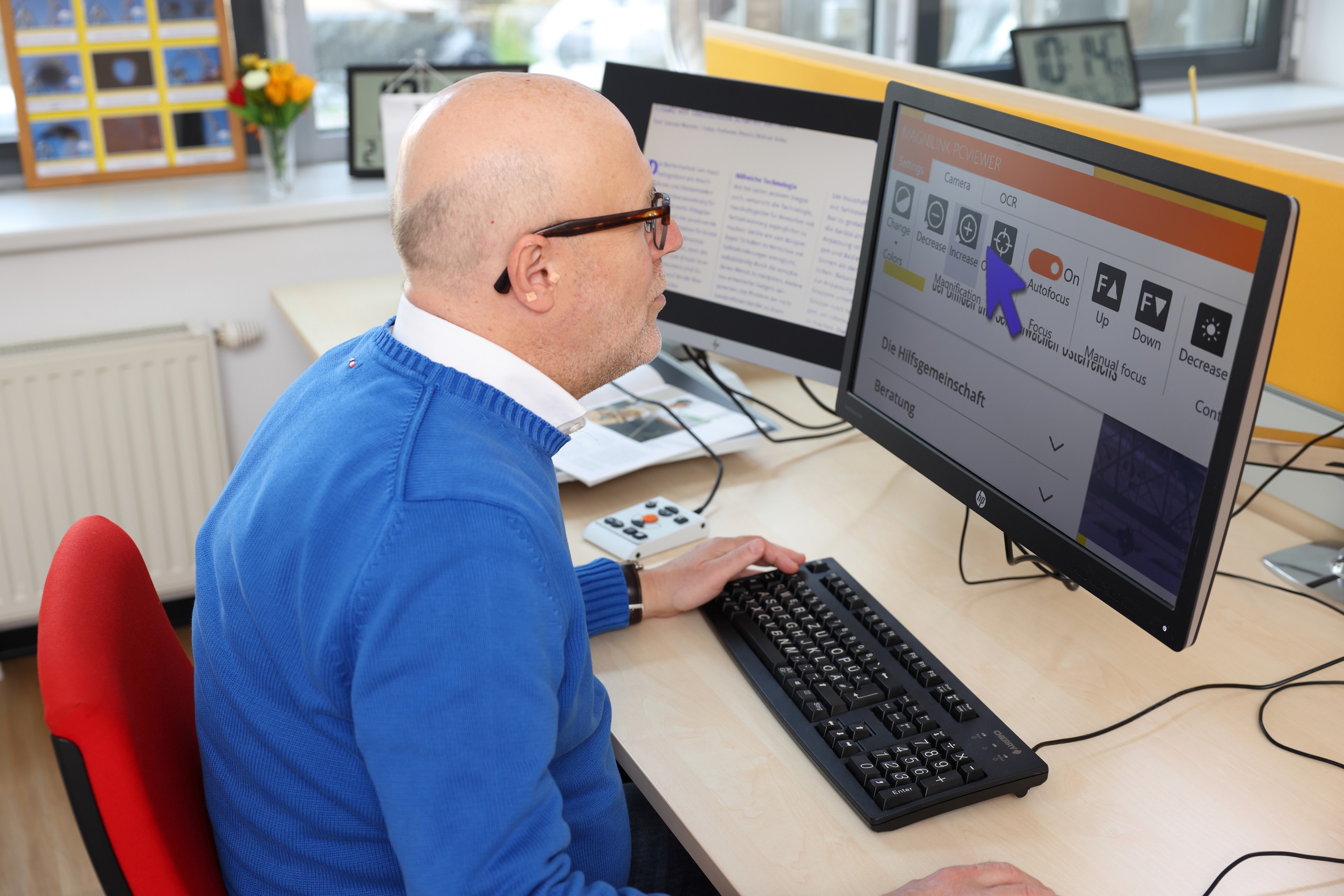 Ein Mann mit Sehbehinderung arbeitet an einem PC. Symbolbild für das Arbeiten von Menschen mit Behinderung