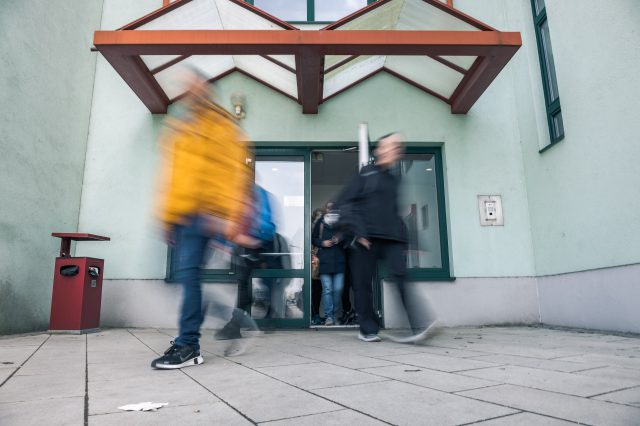 Umrisse von Menschen, die aus einem Bahnhof herauskommen. Symbolbild für den Arbeitsweg mit öffentlichen Verkehrsmitteln.