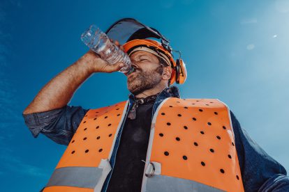 Arbeiter in Sicherheitskleidung schwitzt in der Sonne.