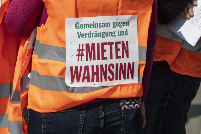 Auf dem Rücken eines:einer Demonstrierenden steht "Gemeinsam gegen Verdrängung und #Mietenwahnsinn". Symbolbild für das Grundrecht auf Wohnen.
