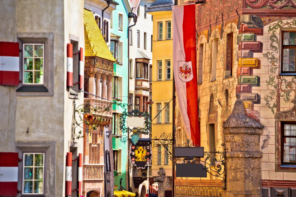 Aufnahme einer Straße in Innsbruck. Zu sehen ist die Altstadt, inkl. Goldenes Dachl und einer Flagge Tirols. Symbolbild für den Tiroler Immobilienmarkt.