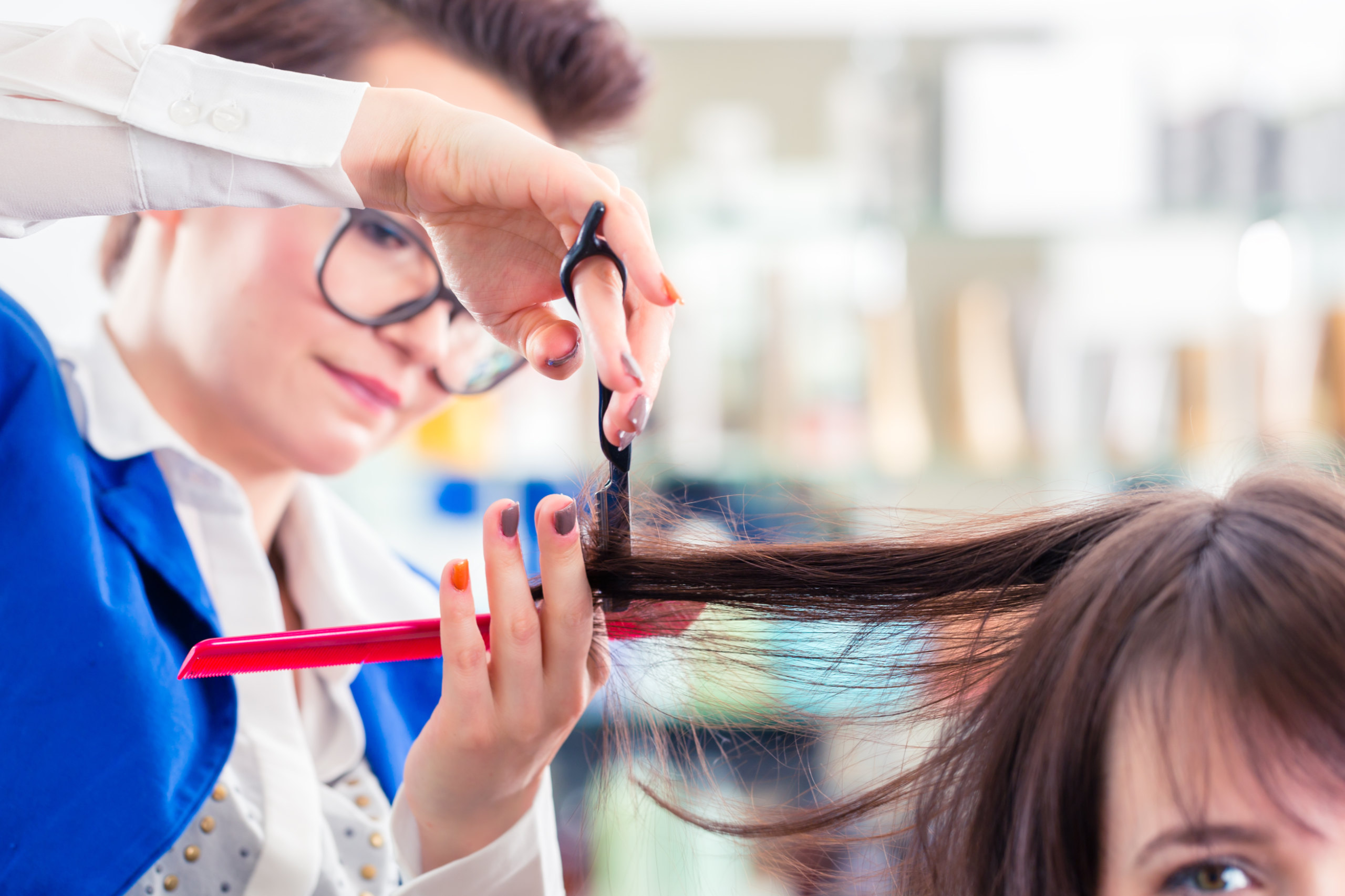 Eine Friseurin schneidet einer Frau die Haare. Symbolbild für entmutigte Arbeitnehmerinnen.