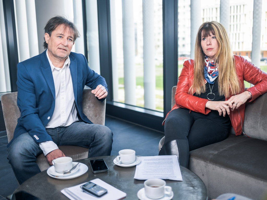 Willi Stöckl und Sandra Steiner sitzen auf Stühlen, vor sich zwei Tassen Kaffee.