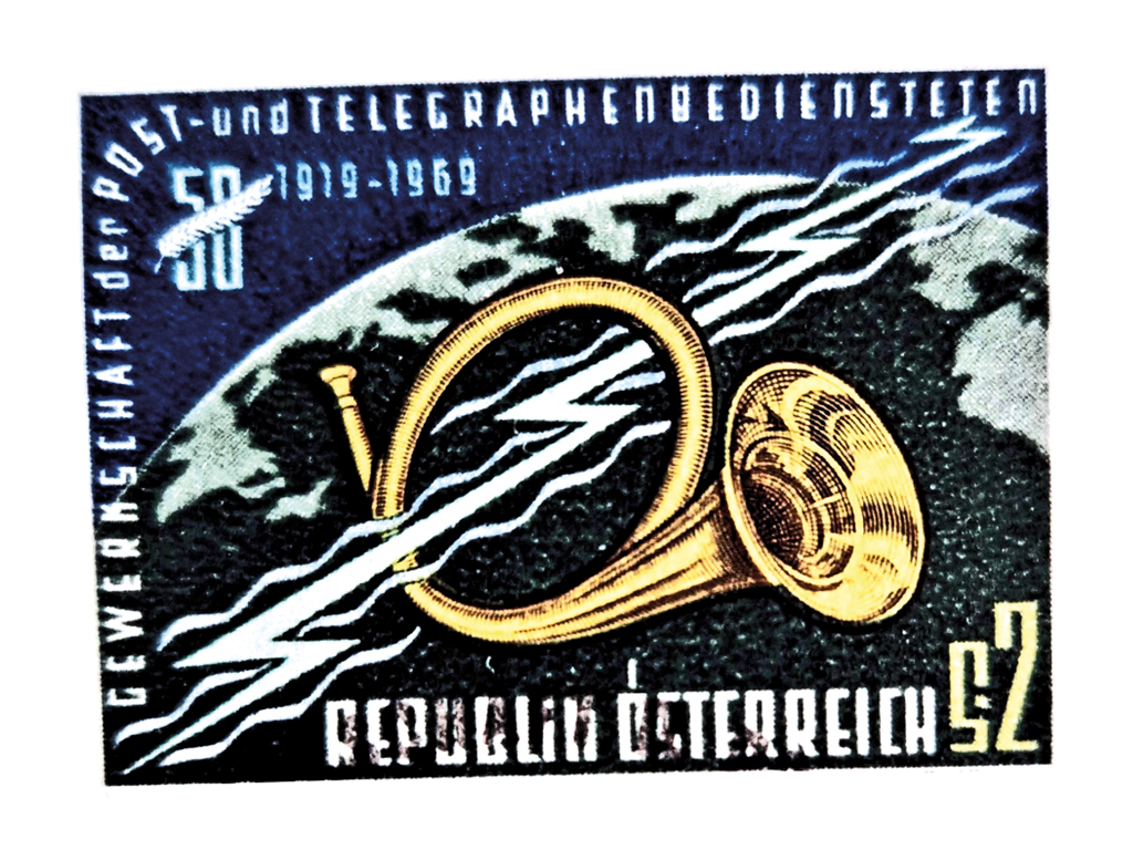 Eine Briefmarke mit der Aufschrift "Gewerkschaft der Post- und Telegrafenbediensteten 1919-1969, Republik Österreich". Über einem Erdball schwebt ein Posthorn, durch dieses geht ein Elektrizitätsblitz. Symbolbild für den Wandel der Technologie in Mobilität und Kommunikation.