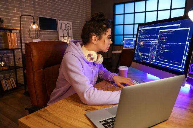Eine junge Frau sitzt vor ihrem Rechner und programmiert. Symbolbild für Digital Pioneers.