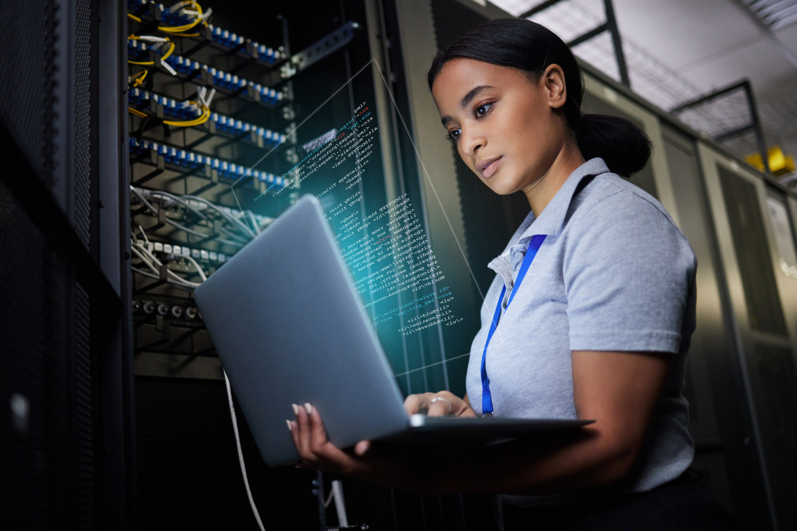 Ein Frau mit Laptop im Arm überprüft die Anschlüsse eines Servers. Symbolbild für Digital Pioneers.