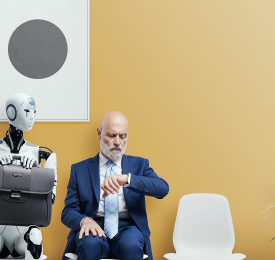Ein Roboter und ein Mann sitzen nebeneinander auf Stühlen und warten auf eine Besprechung. Der Roboter hat einen Aktenkoffer auf seinen Knien abgelegt. Der Mann schaut auf seine Armbanduhr. Symbolbild für KI und ihre Rolle in der Arbeitswelt.