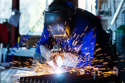 Beschäftigte der Metallindsutrie freuen sich am Arbeitsplatz. Symbolbild für die KV-Verhandlungen in der Herbstlohnrunde 2023.