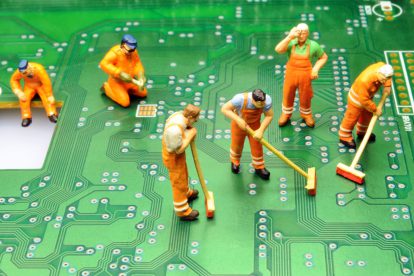 Kleine Figürchen reinigen einen Computer von Innen. Symbolbild für die Digitalisierung.
