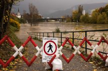 Eine Schild und eine Absperrung warenen davor eine Straße zu betreten, die überschwemmt ist. Symbolbild für den Klimawandel.