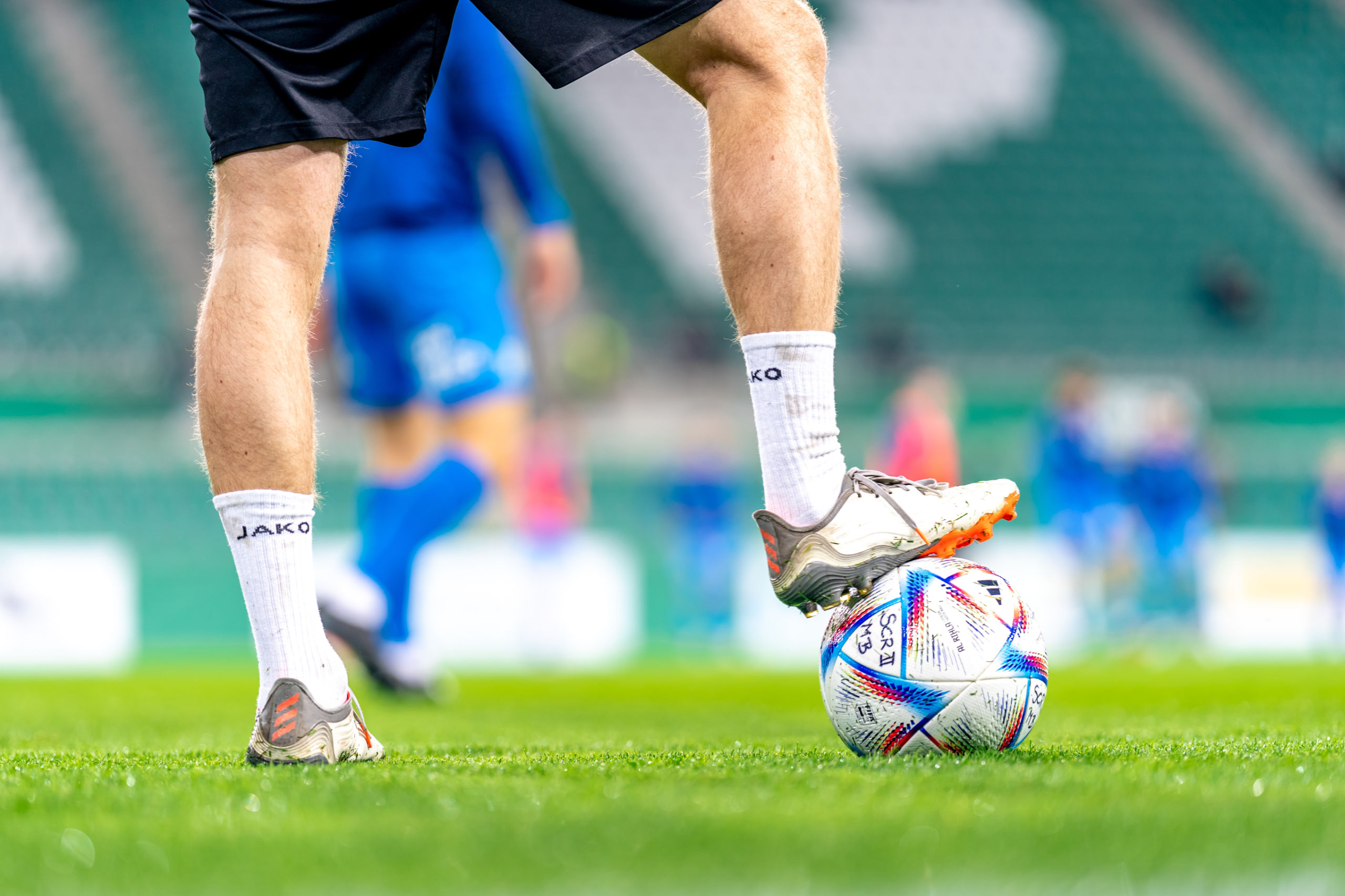 Ein Fußballspieler steht mit dem rechten Bein auf einem Fußball. Symbolbild für den Kollektivvertrag im Fußball.