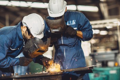 Arbeiter der Metallindustrie in der Werkstatt. Es fliegen Funken. Symbolbild für die KV-Verhandlungen der Metaller und die Herbstlohnrunde.