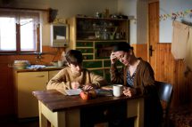 Ein alleinerziehende Mutter sitzt mit ihrem Sohn an einem Esstisch. Sie lebt in Armut in Österreich.