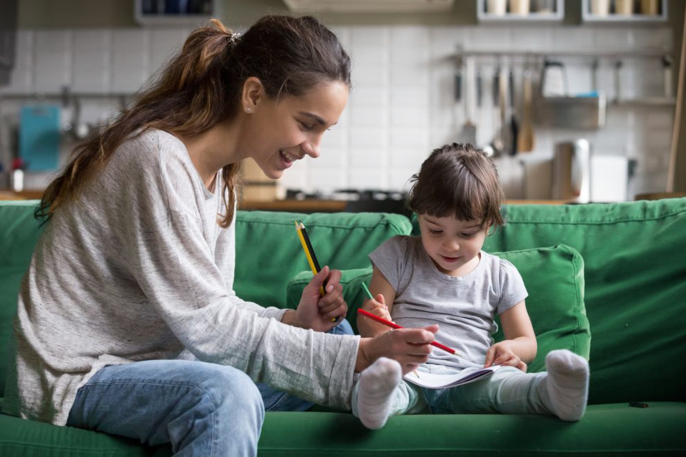 Eine junge Frau passt als Babysitterin auf ein kleines Kind auf und spielt mit ihm auf der Couch. Solche Arbeiten vermittelt betreut.at