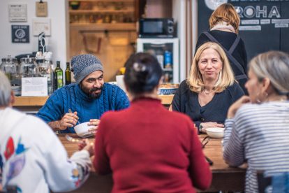 Menschen sitzen um einen Tisch und essen. Symbolbild für den Migrant:innenbeirat in Graz.
