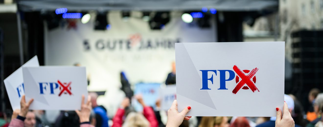 Bei einer Wahlkampfveranstaltung halten Menschen FPÖ-Plakate in die Luft. Symbolbild für die FPÖ bei der Wien-Wahl.