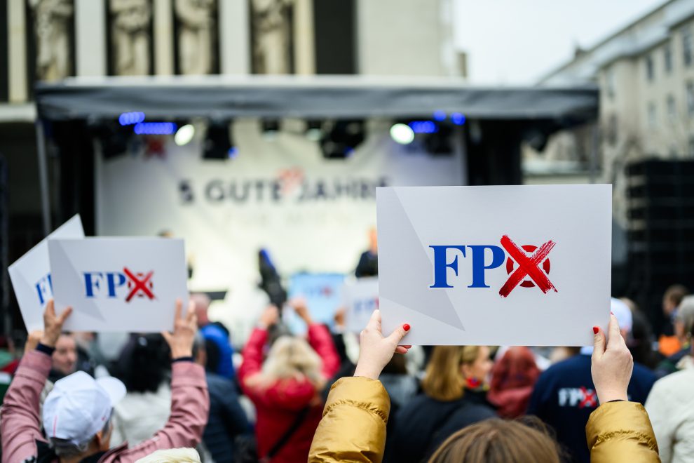 Bei einer Wahlkampfveranstaltung halten Menschen FPÖ-Plakate in die Luft. Symbolbild für die FPÖ bei der Wien-Wahl.