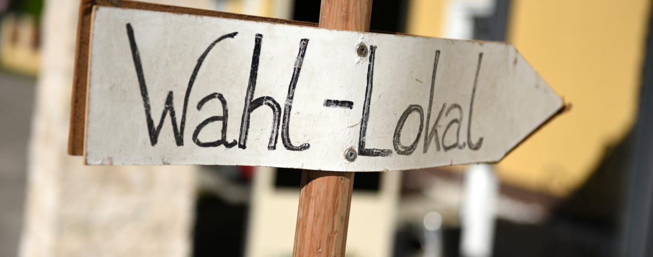 Schild eines Wahllokals in Österreich. Symbolbild für Österreich politische Beteiligung