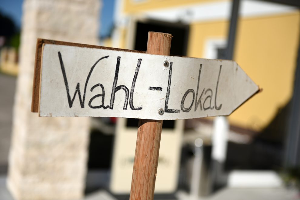 Schild eines Wahllokals in Österreich. Symbolbild für Österreich politische Beteiligung