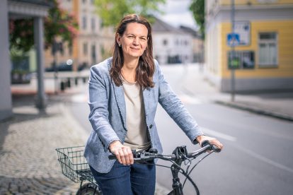 Porträt Kerstin Suchan-Mayr. Sie steht neben ihrem Fahrrad.