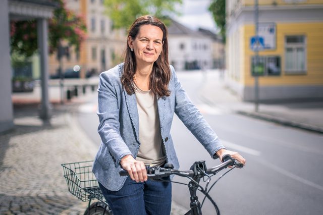 Porträt Kerstin Suchan-Mayr. Sie steht neben ihrem Fahrrad.