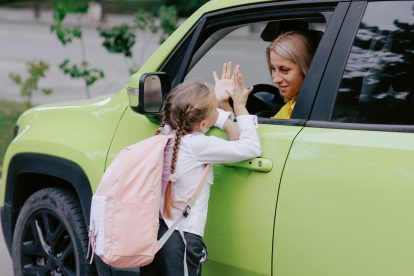 Mutter und Tochter verabschieden sich am ersten Schultag emotional durch das Autofenster. Symbolbild für die Teilzeitdebatte.