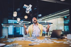 Ein Mann schmeißt Geld in die Luft.
