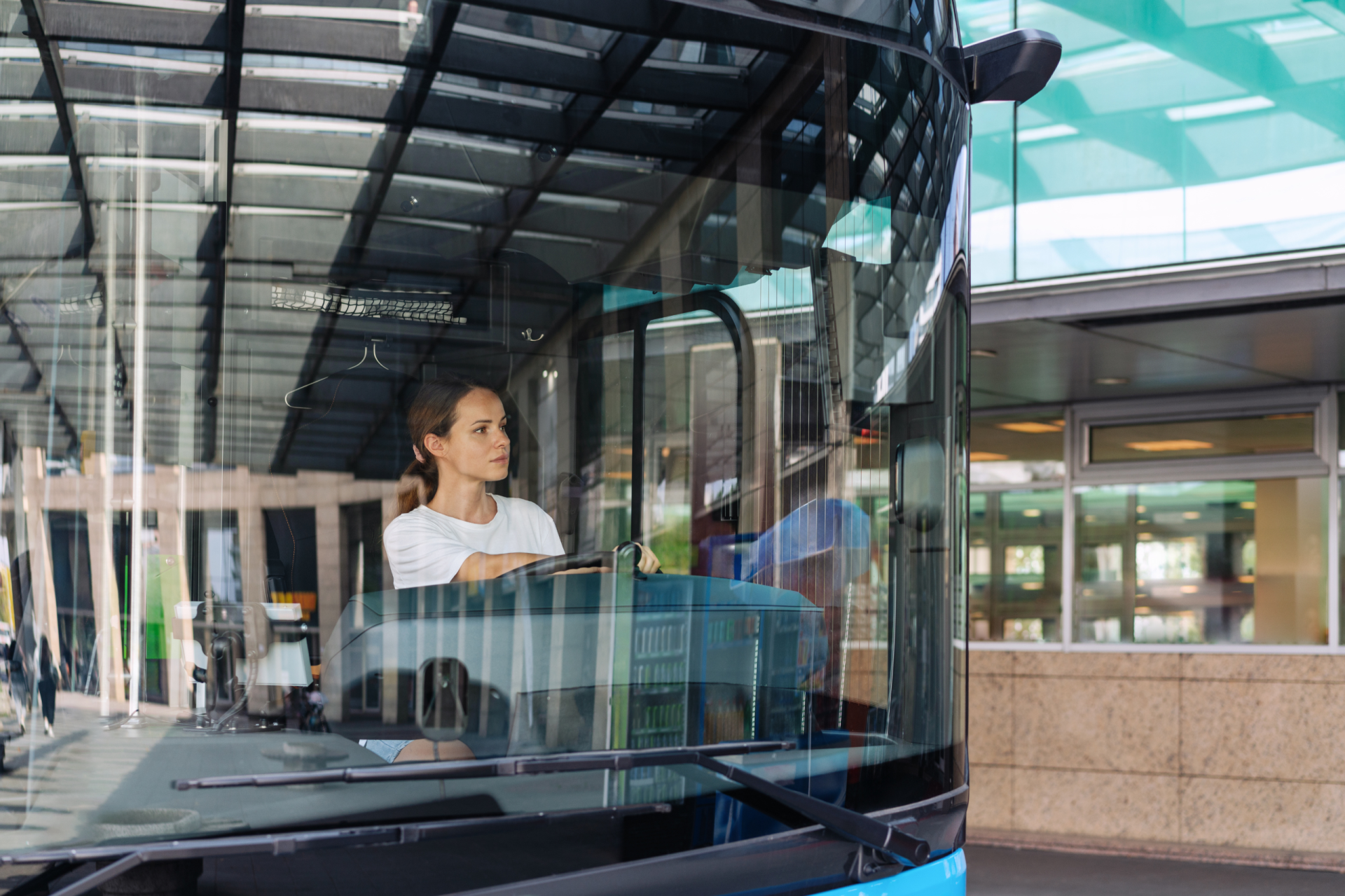 Eine Busfahrerin sitzt am Steuer. Symbolbild für die Verhandlungen der Beschäftigten in privaten Autobusbetrieben.