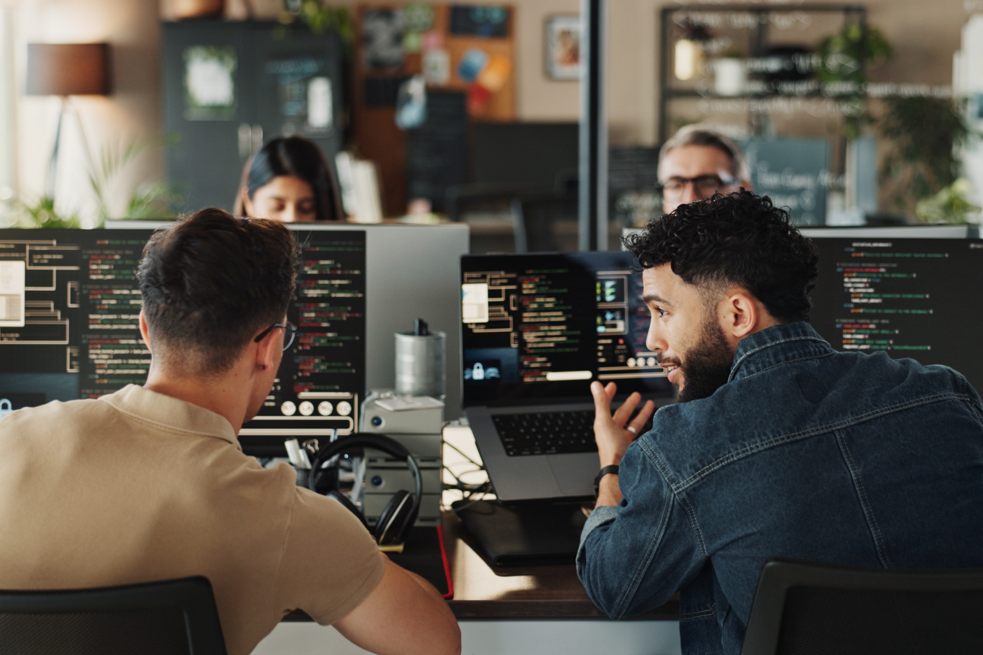 Mehrere Menschen in der IT-Branche vor Computer. Symbolbild für die Kollektivvertragsverhandlungen.