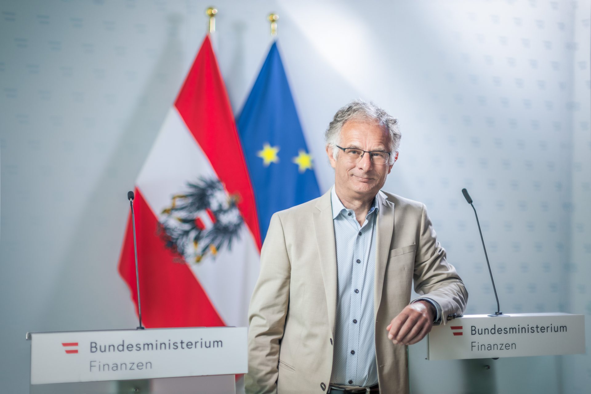 Finanzminister Marterbauer steht vor der österreichischen und europäischen Flagge. | © Markus Zahradnik