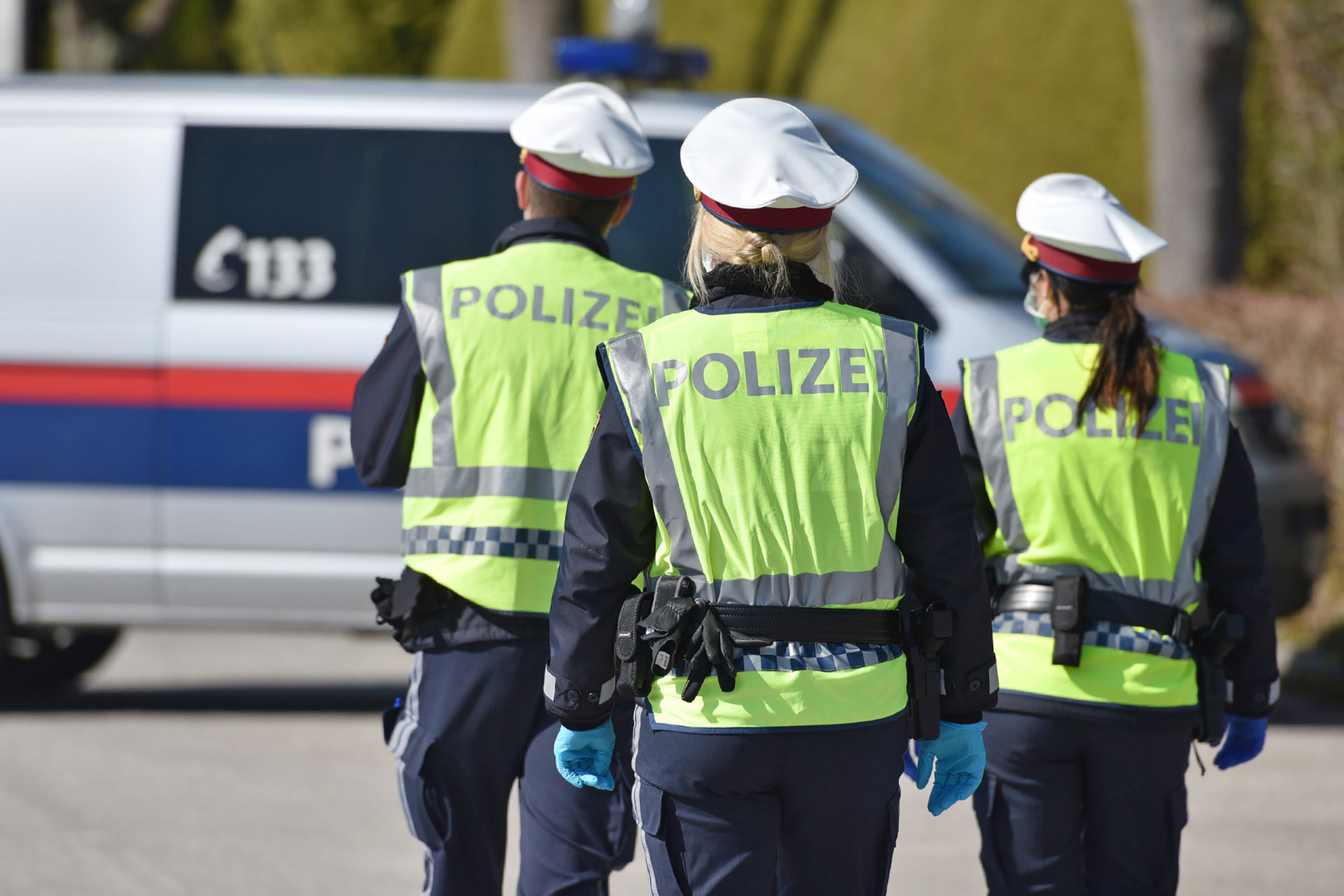 Drei Polizisten vor ihrem Polizeiauto. Symbolbild für: Nachdem im Vorjahr bereits die Gehaltsanpassung vereinbart wurde, gab es heute auf Wunsch der Regierung erneut Verhandlungen. 