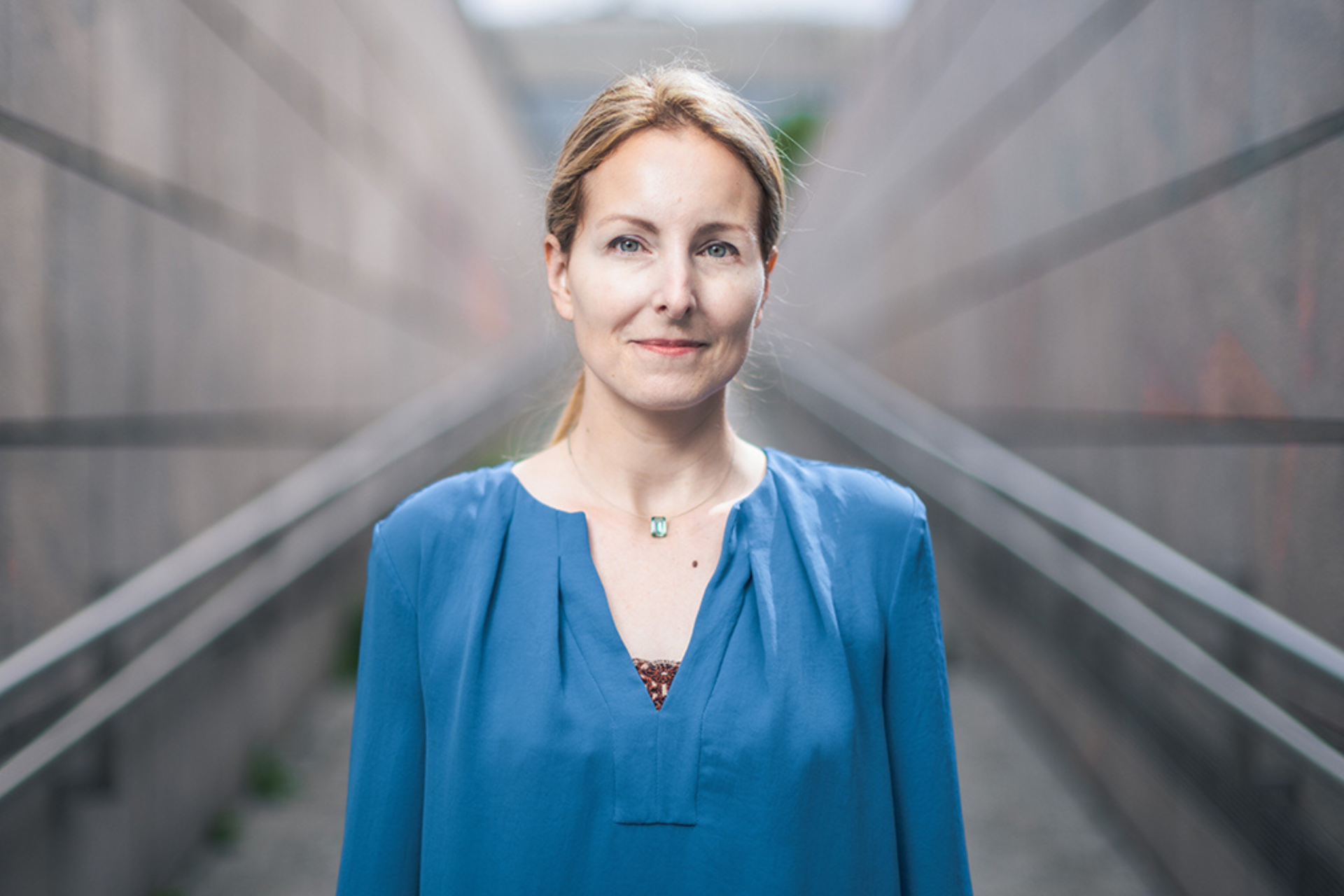 Politologin Tina Ehs steht vor einem unscharfen Hintergrund. Symbolbild für den Zustand der Demokratie in Österreich.