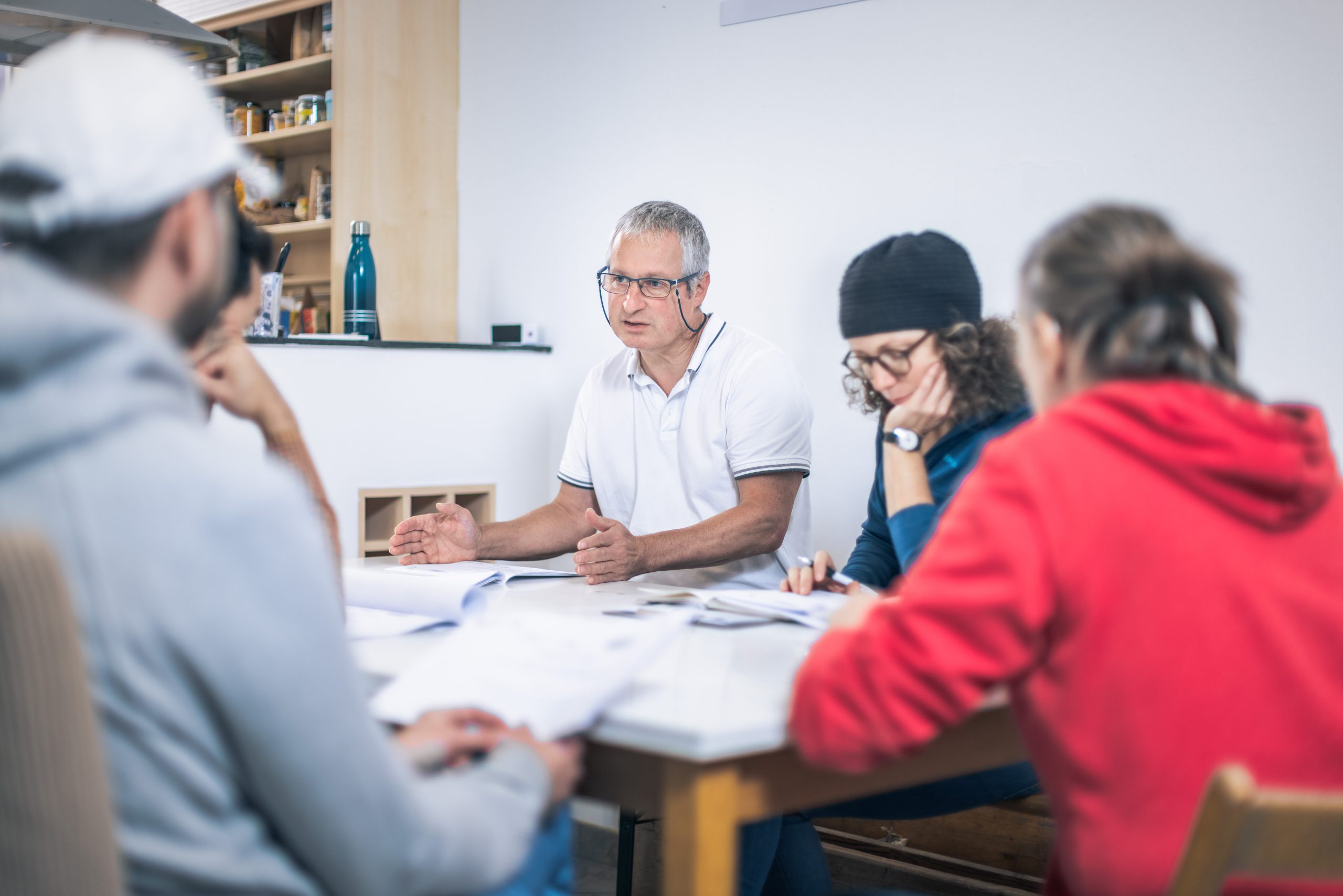 Menschen sitzen an einem Tisch und reden. 