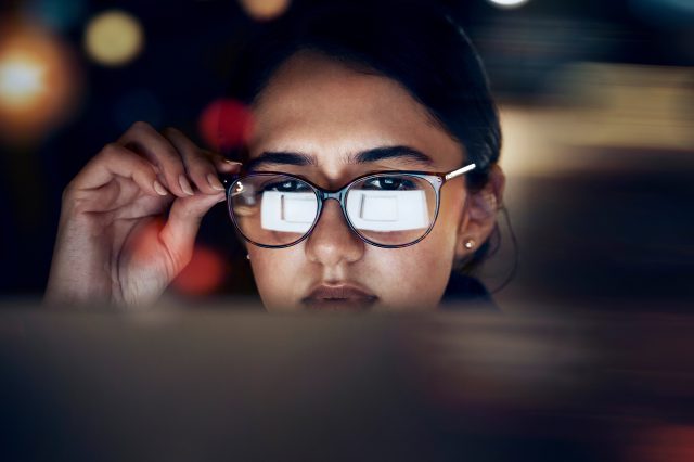 Eine Frau schaut in einen PC. Symbolbild für die Prognose zu Digitalisierung und KI-Hype.