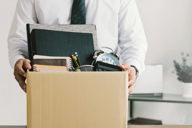 Ein Mann bringt nach einer Kündigung seine Sachen in einer Box nach Hause. Symbolbild: Betriebsrät:innen fangen Menschen nach Kündigungen auf.